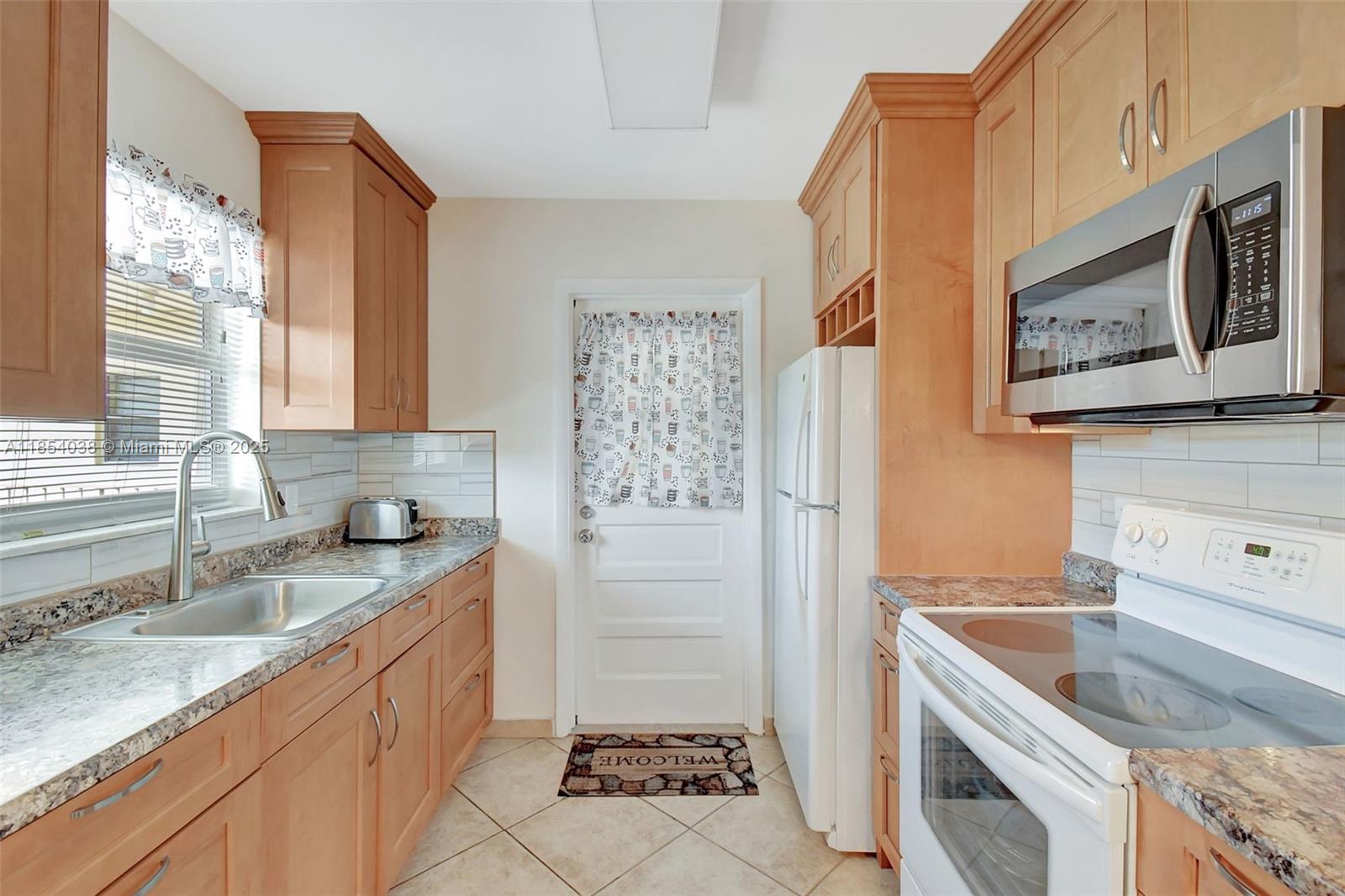 415 Northeast 2nd Street, Unit 201 Hallandale Beach, FL 33009 - Photo 3 of 34 a kitchen with stainless steel appliances granite countertop a sink stove and refrigerator