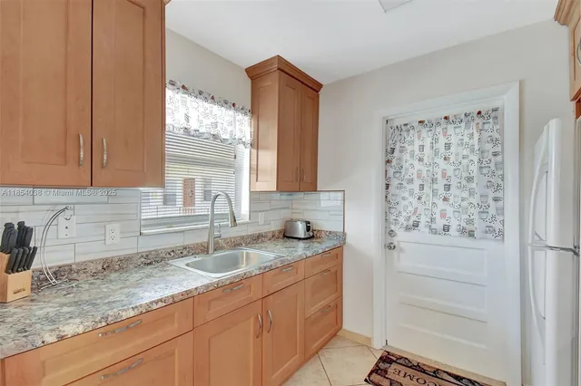 a bathroom with a granite countertop sink a mirror and a shower