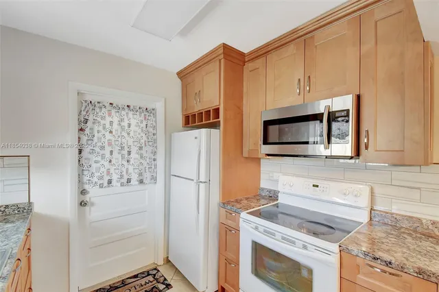 a kitchen with stainless steel appliances white cabinets and a refrigerator