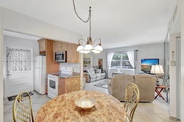 a living room with furniture a chandelier and a dining table