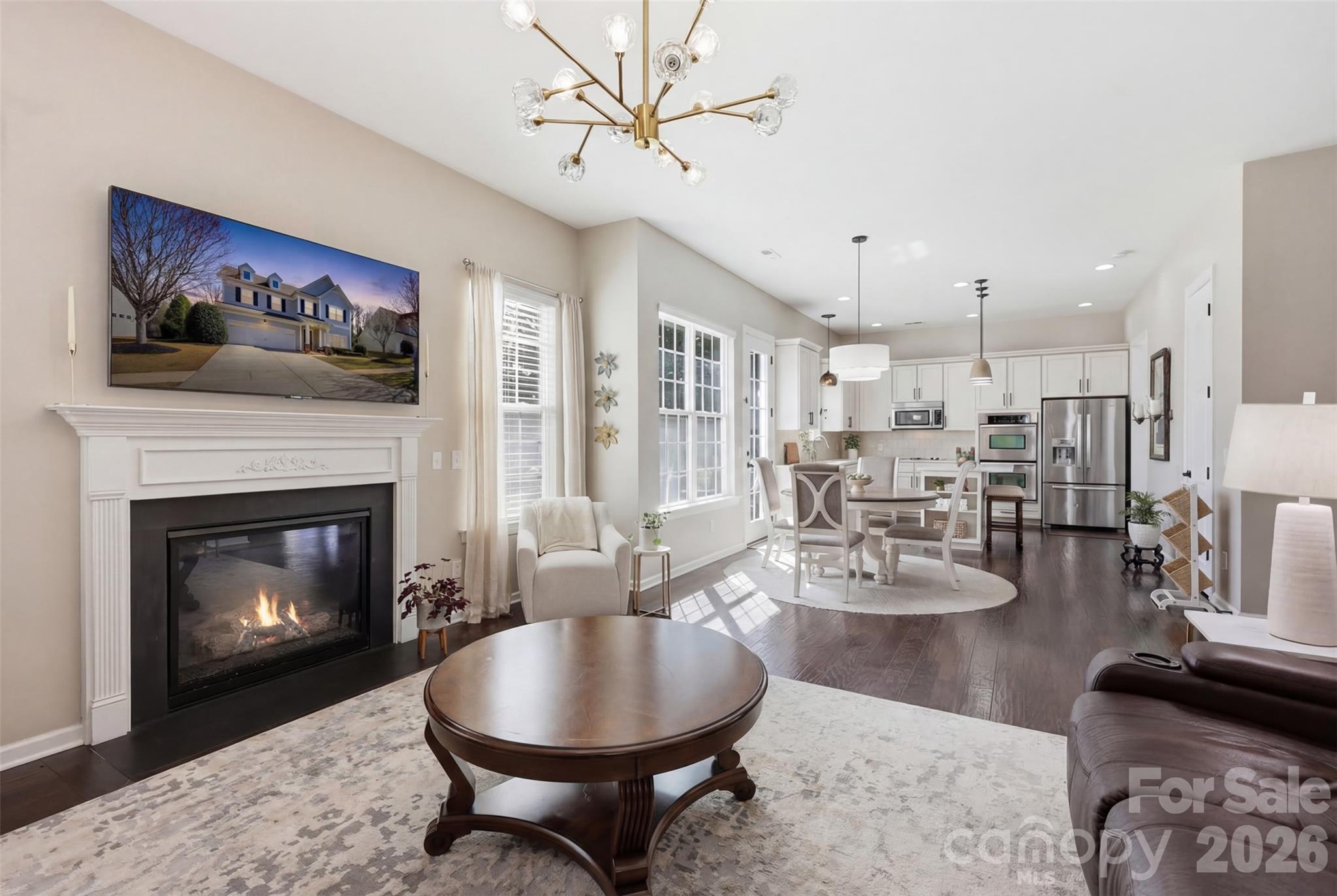 1210 Gold Rush Court Fort Mill, SC 29708 - Photo 1 of 39 a living room with couches a fireplace and kitchen view with wooden floor