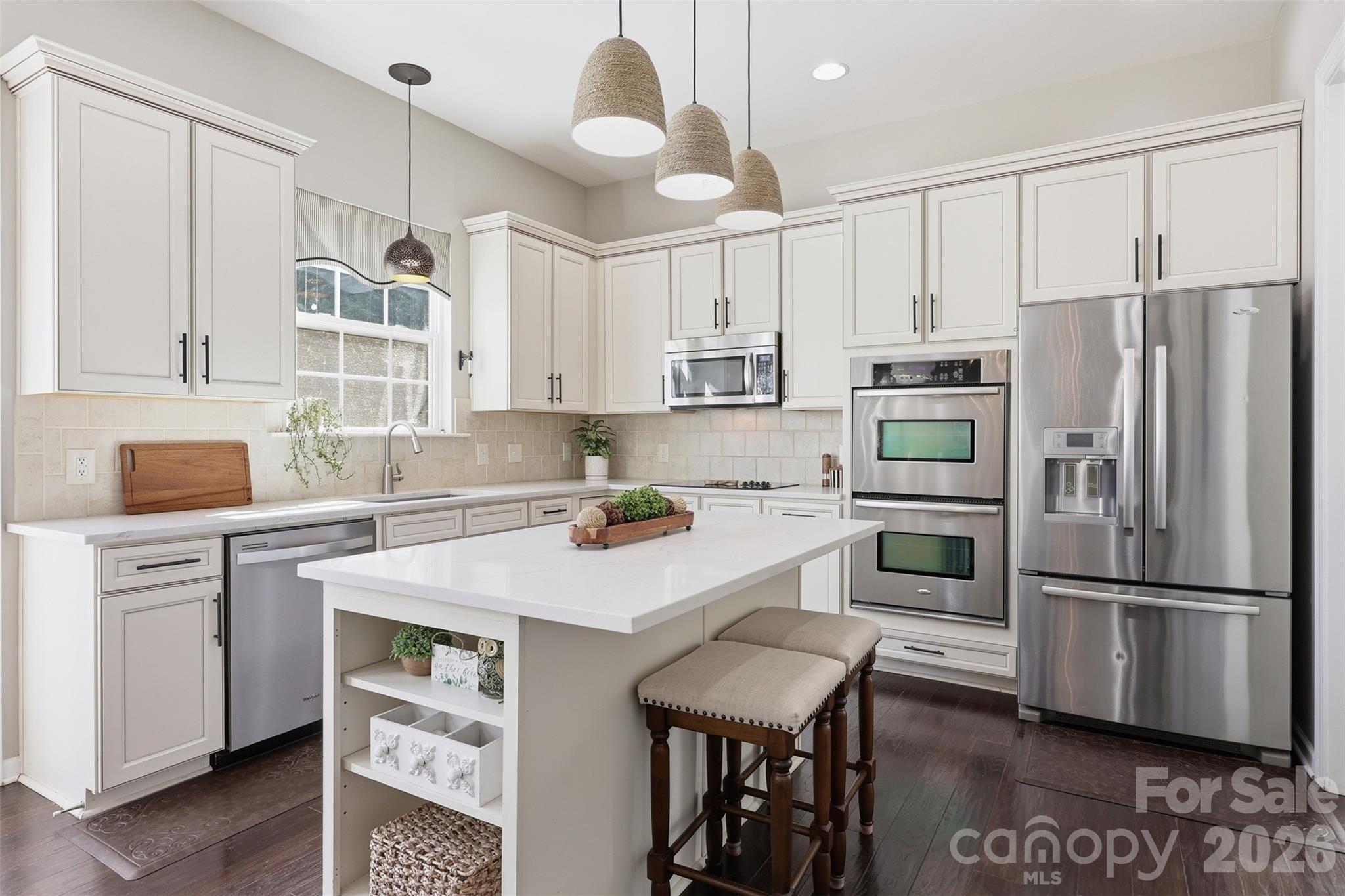1210 Gold Rush Court Fort Mill, SC 29708 - Photo 4 of 39 a kitchen with granite countertop a refrigerator a stove a sink and white cabinets with wooden floor