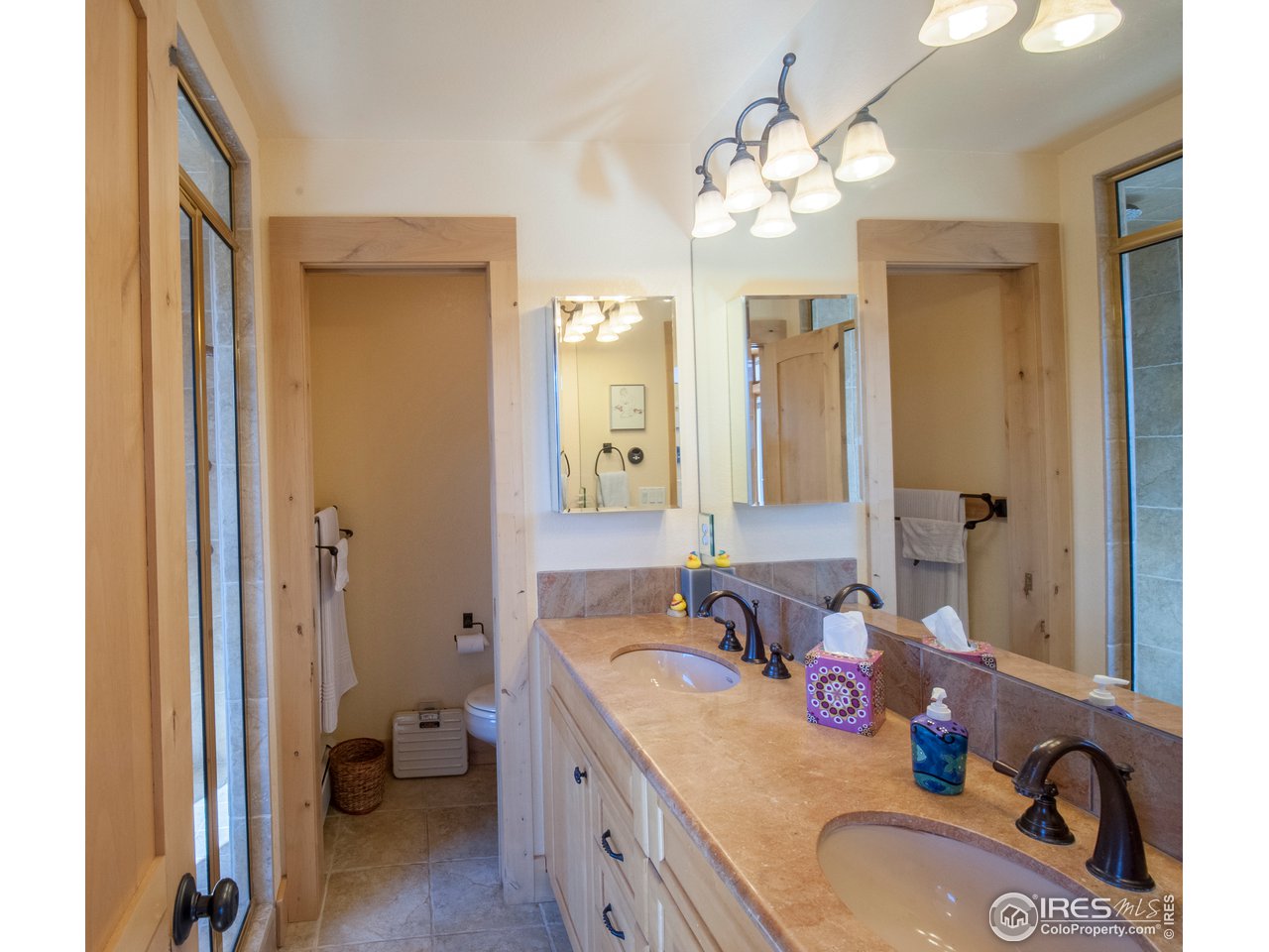 4900 Ridge Road Boulder, CO 80302 - Photo 20 of 38 a spacious bathroom with a granite countertop sink a toilet a mirror and shower