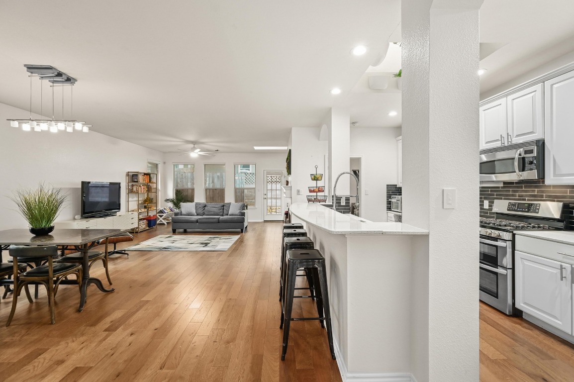 2721 Kinney Oaks Court Austin, TX 78704 - Photo 4 of 28 a view of a kitchen with kitchen island wooden floors appliances and furniture