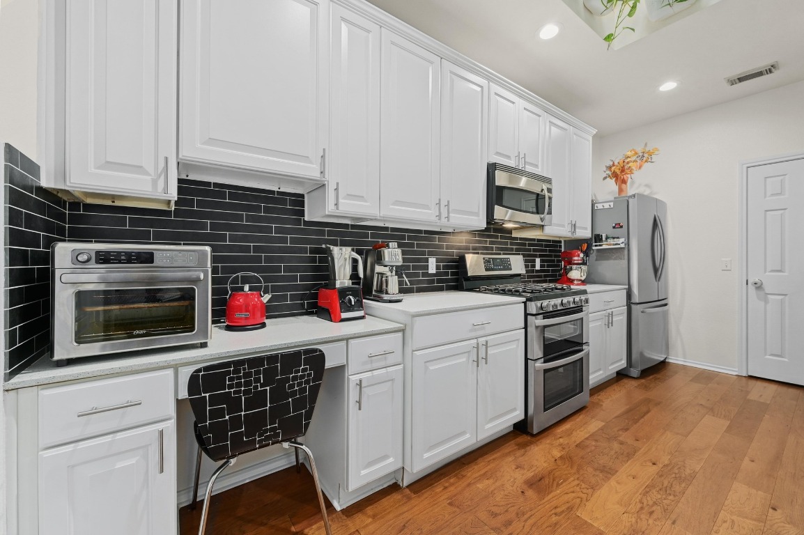 2721 Kinney Oaks Court Austin, TX 78704 - Photo 8 of 28 a kitchen with stainless steel appliances a stove a sink and a refrigerator