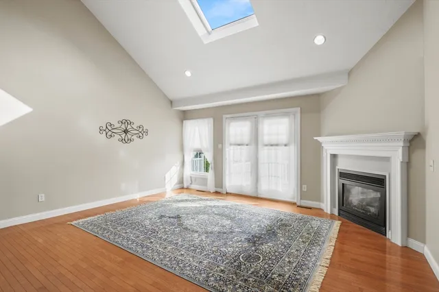 a view of empty room with wooden floor and fireplace