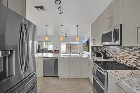 a kitchen with stainless steel appliances granite countertop a stove refrigerator sink and microwave