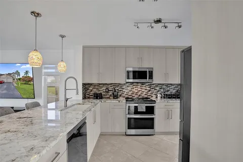 a kitchen with stainless steel appliances granite countertop a stove a sink and a granite counter tops