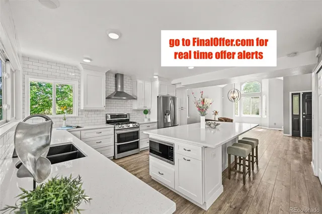 a kitchen with stainless steel appliances kitchen island granite countertop a stove a sink and a refrigerator