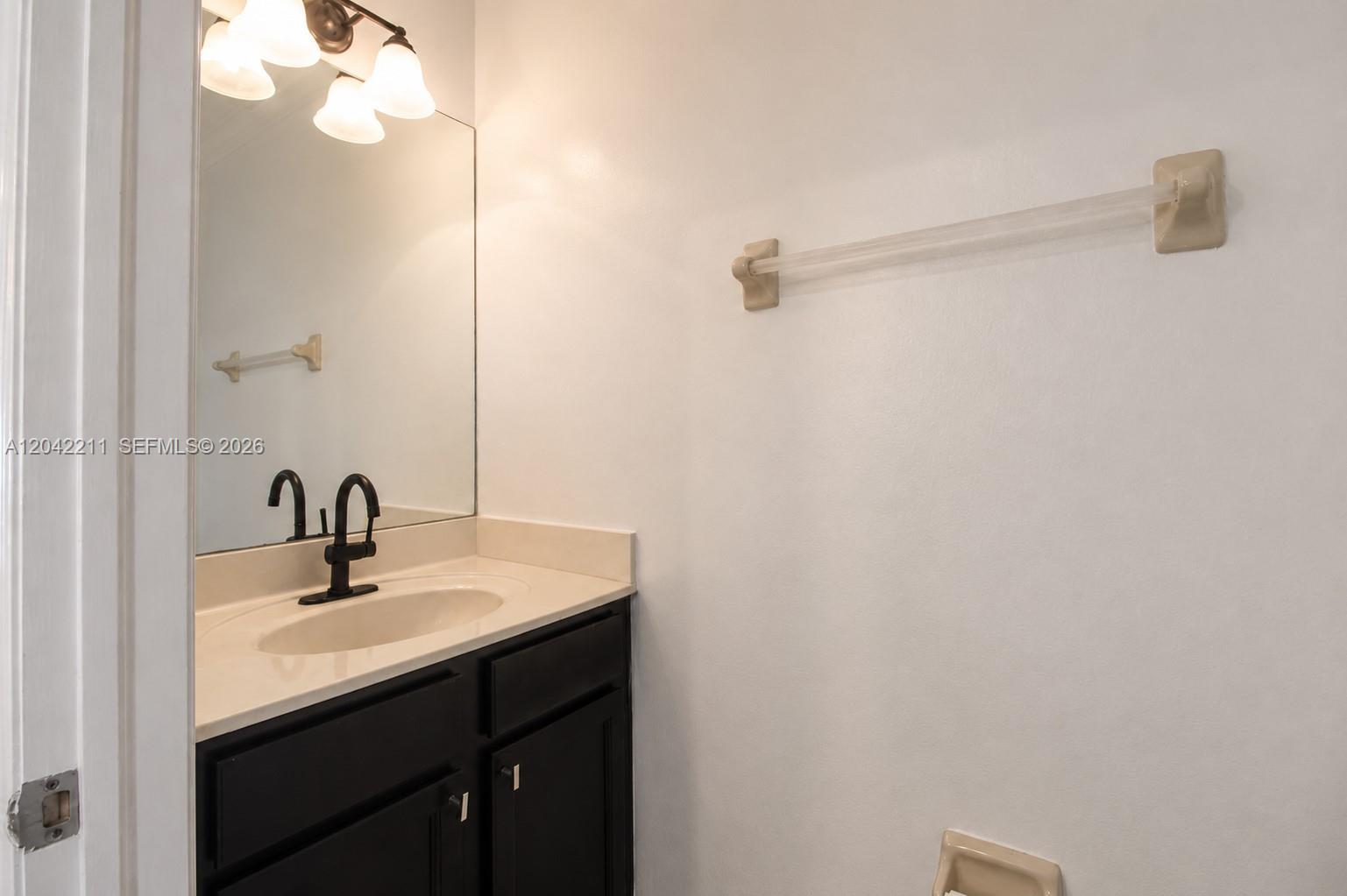 8954 West 35th Way Hialeah, FL 33018 - Photo 11 of 24 a bathroom with a sink a mirror and vanity