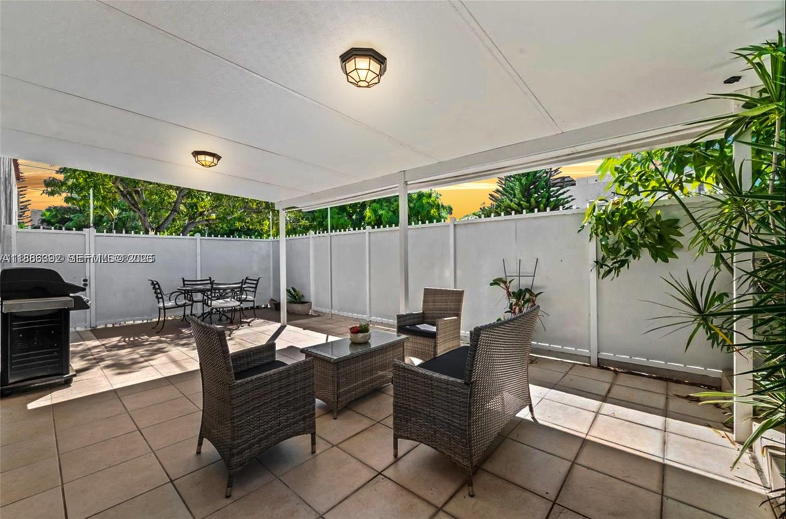 a outdoor space with lots of tables a garden and a couch