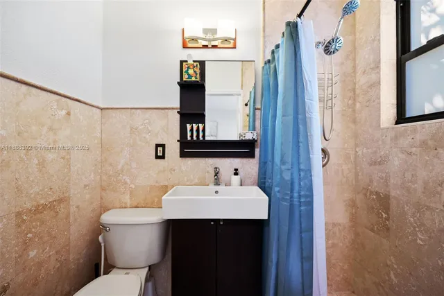 a bathroom with a sink mirror toilet and shower