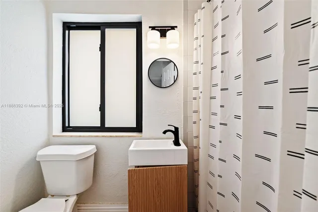 a bathroom with a toilet sink and mirror