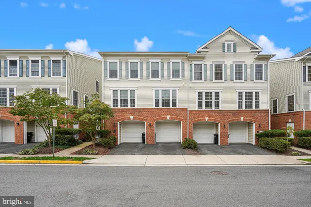 a front view of a building with a yard and plants