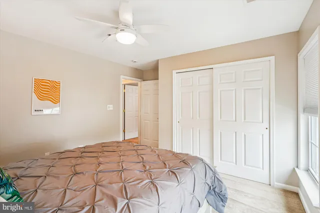 a bedroom with a large bed and a chandelier fan