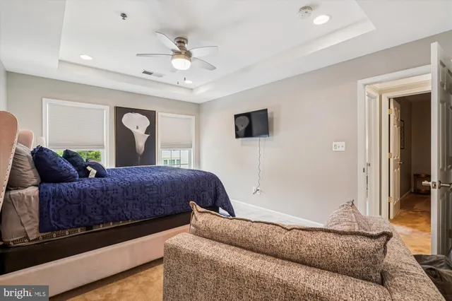 a living room with a bed furniture and a flat screen tv