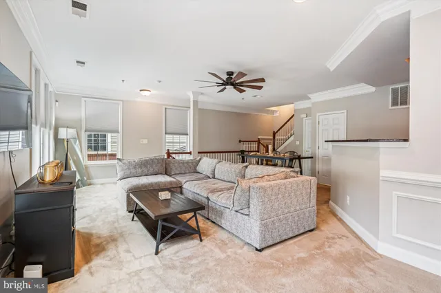 a living room with furniture a table and kitchen view