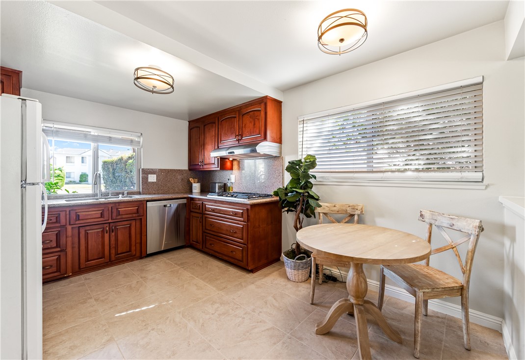 10191 Virgil Circle Cypress, CA 90630 - Photo 13 of 53 a kitchen with a table chairs a sink and dishwasher