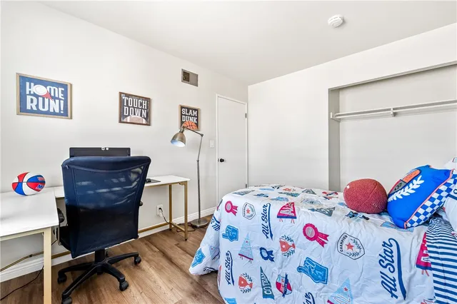 a bedroom with a bed and painting on the wall