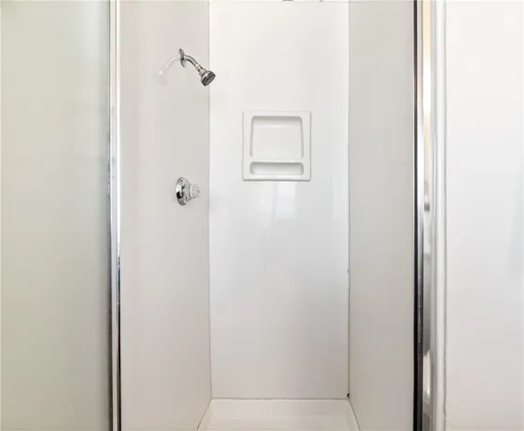 a view of a patio with table and chairs under an umbrella with a large tree