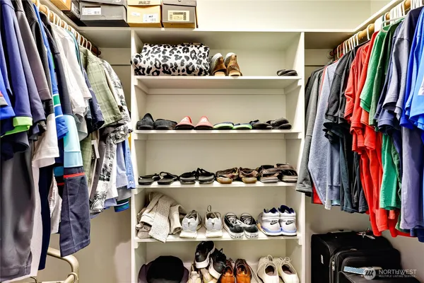 a view of walk in closet with clothes and shoes