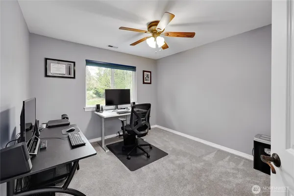 a view of a workspace with furniture and a window
