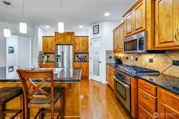 a kitchen with stainless steel appliances granite countertop a stove and a refrigerator