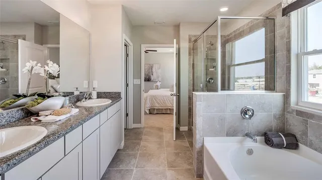 a spacious bathroom with a tub sink and mirror