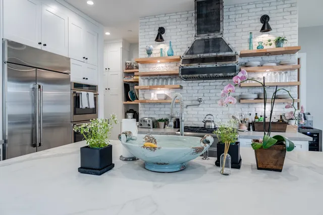 a kitchen with furniture a refrigerator and potted plant