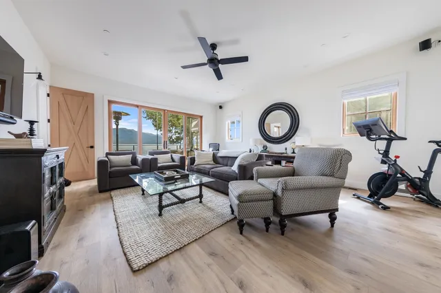 a living room with furniture a large window and a flat screen tv