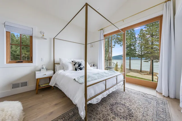 a room with a bed and large window with outer view