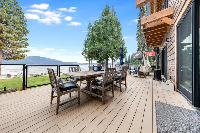 a view of a roof deck with table and chairs floor to ceiling with wooden floor