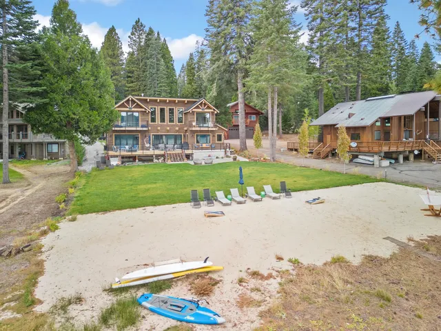 a view of a big house with a big yard and large trees