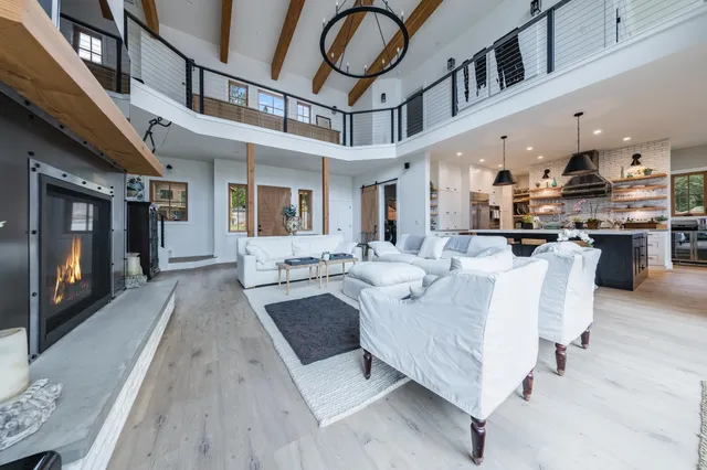 a living room with furniture a flat screen tv and kitchen view