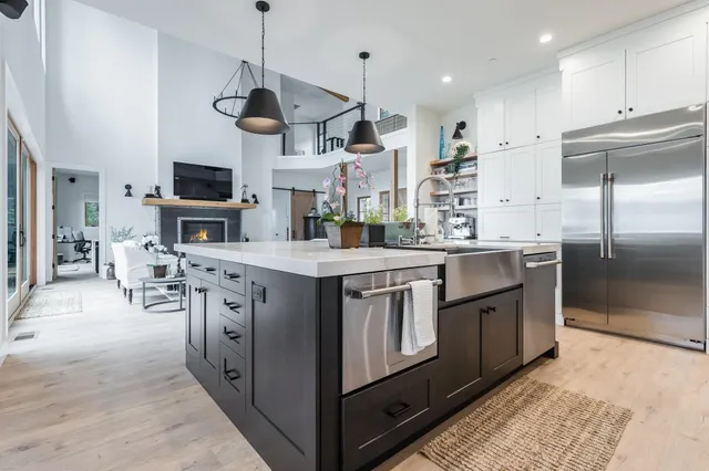 a kitchen with stainless steel appliances granite countertop a sink a stove and a refrigerator