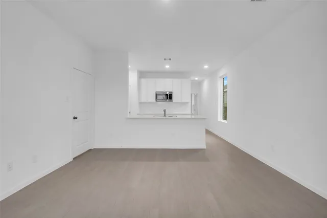 a kitchen with stainless steel appliances a sink a microwave a refrigerator and cabinets