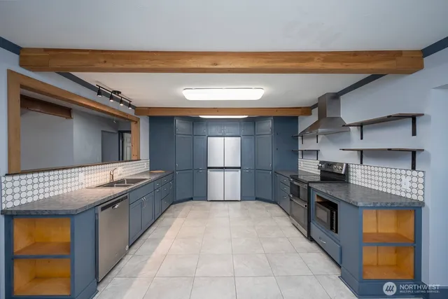 a kitchen with stainless steel appliances granite countertop a stove a sink and a refrigerator