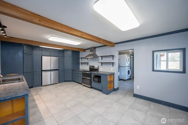 a kitchen with stainless steel appliances kitchen island granite countertop a refrigerator stove and sink