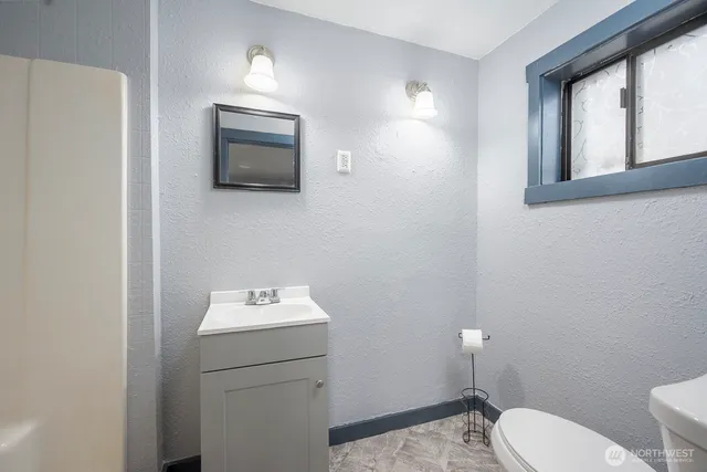 a bathroom with a toilet a sink and mirror
