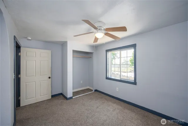 an empty room with closet and windows