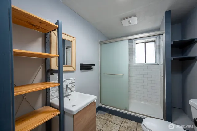 a bathroom with a sink a toilet and shower