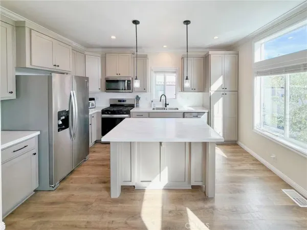 a kitchen with kitchen island a refrigerator stove microwave and cabinets