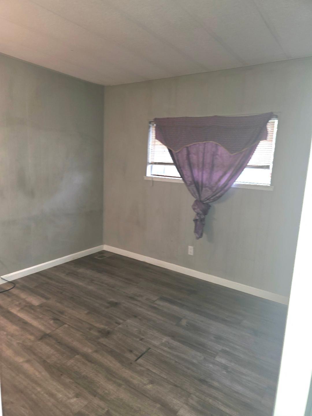 264 Mercury Circle Gustine, CA 95322 - Photo 12 of 18 a view of an empty room with wooden floor and a window