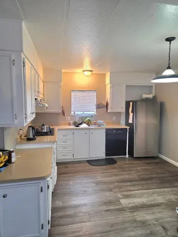 a kitchen with granite countertop white cabinets and white appliances