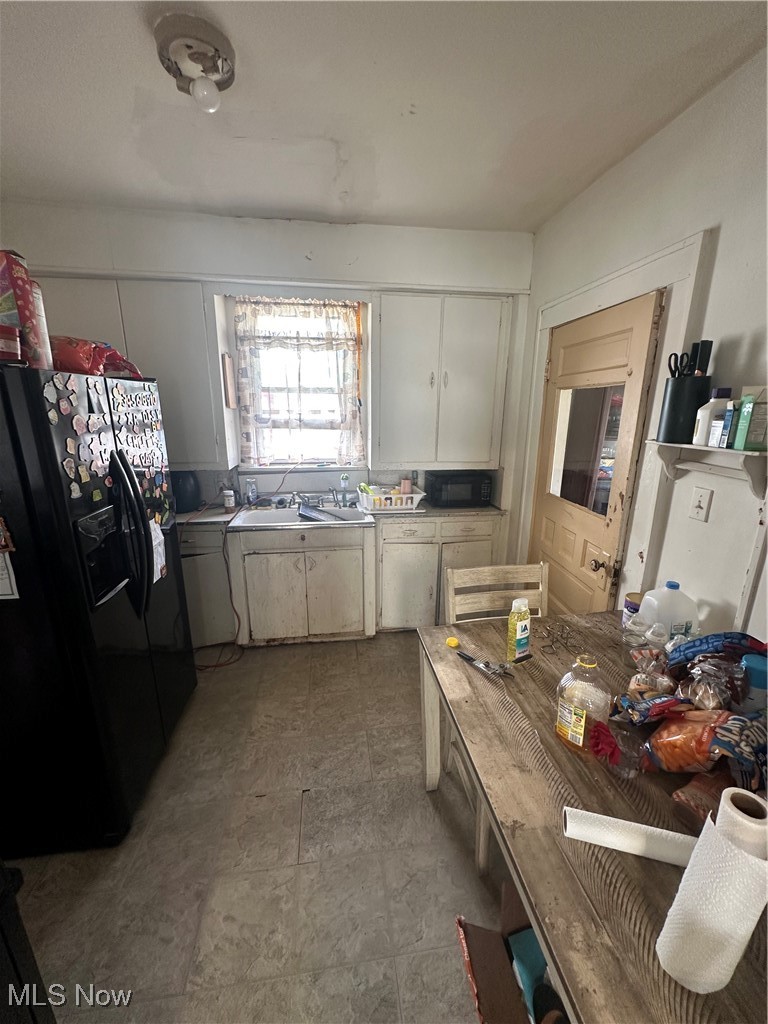 757 Noah Avenue Akron, OH 44320 - Photo 5 of 16 Kitchen featuring fridge, white cabinets, light countertops, and a sink