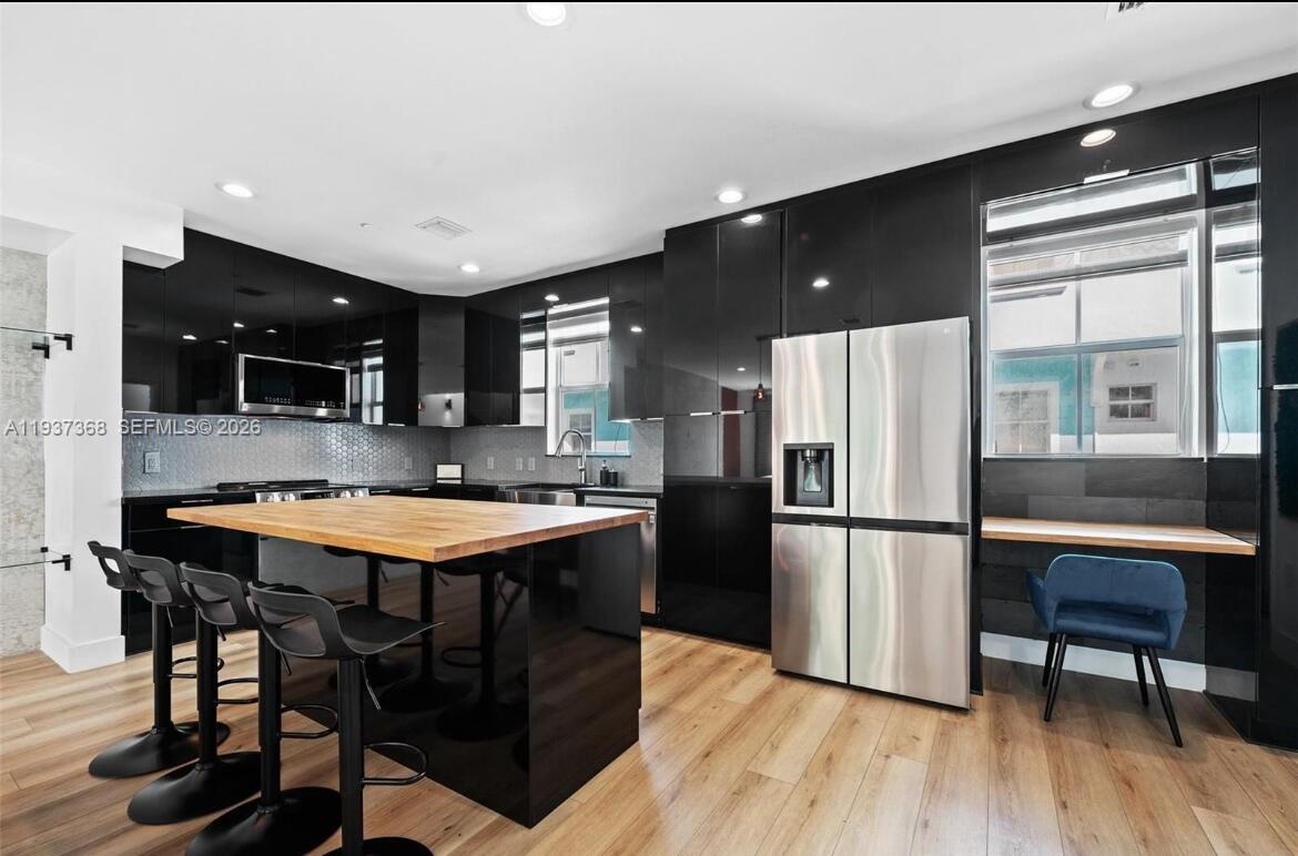 1705 Johnson Street, Unit B Hollywood, FL 33020 - Photo 6 of 34 a kitchen with stainless steel appliances granite countertop a refrigerator a sink dishwasher a stove and a refrigerator with wooden floor