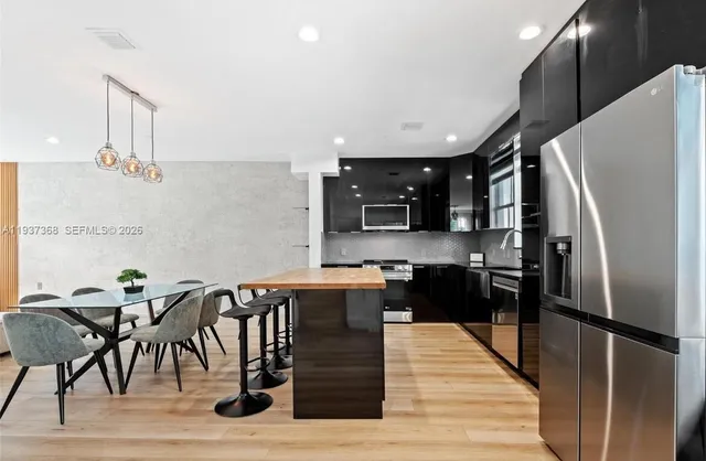 a kitchen with stainless steel appliances granite countertop a refrigerator a stove top oven and cabinets