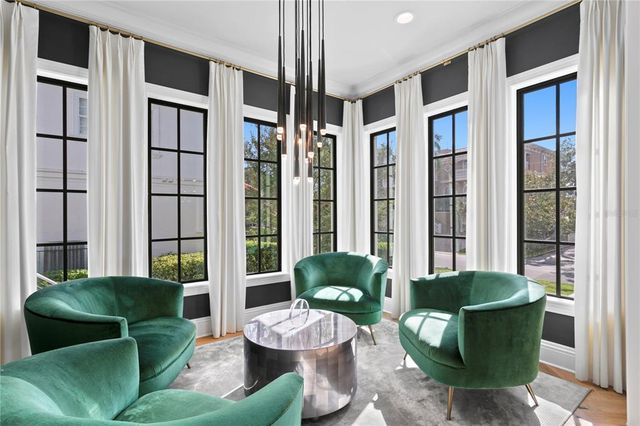 a living room with furniture kitchen and a large window