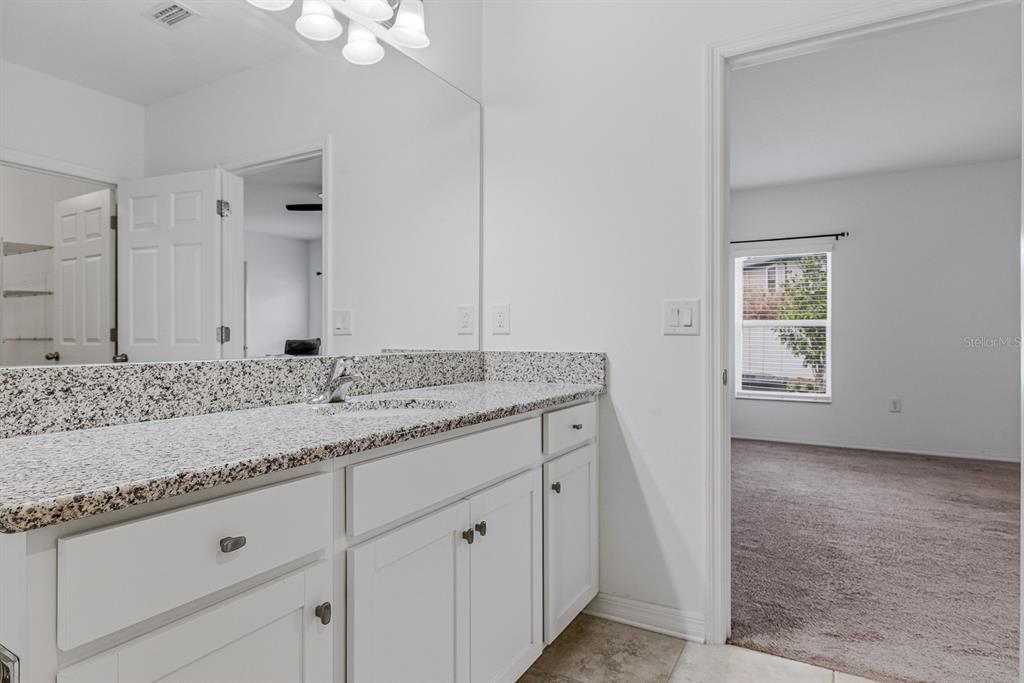 12218 Gothic Rd Spring Hill Spring Hill, FL 34610 - Photo 26 of 56 a bathroom with a granite countertop sink and a mirror