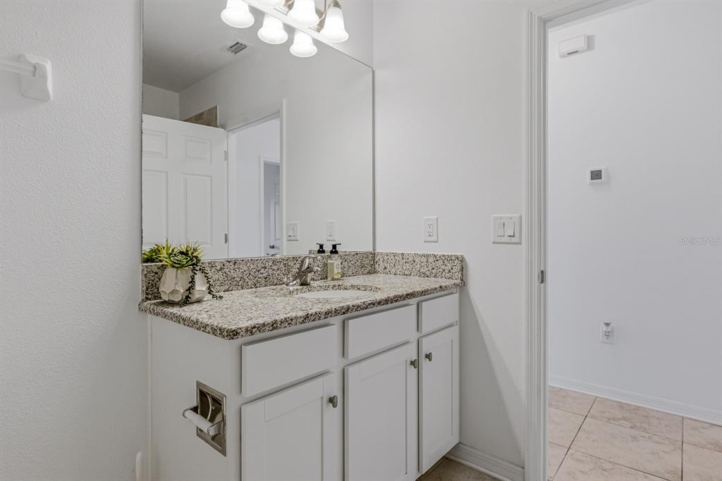 12218 Gothic Rd Spring Hill Spring Hill, FL 34610 - Photo 29 of 56 a bathroom with a granite countertop sink and a mirror